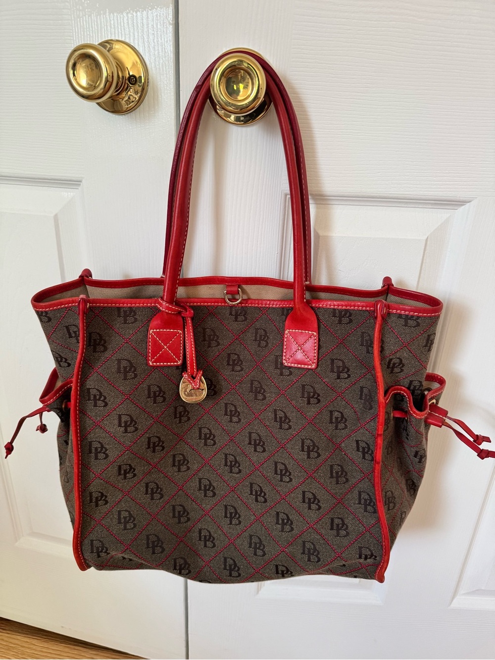 Dooney & Bourke Brown Tote with Red Trim and Gold Charm